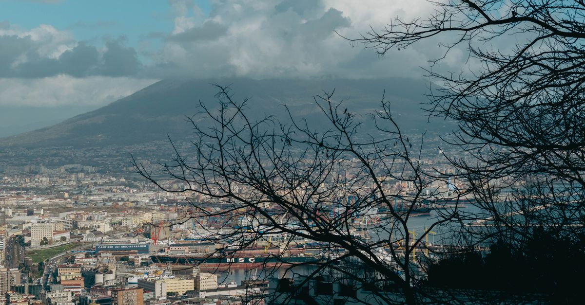 A panoramic view of Naples, Italy with Mount Vesuvius in the background, captured during the day.